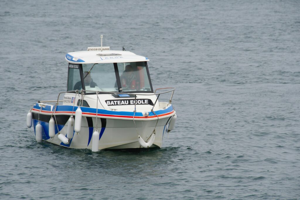 A motorboat labeled 'Bateau Ecole' traveling on the sea in Dinard, Bretagne, France.